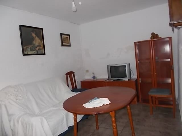 Cozy living room in a town house in Tijola, Almeria, featuring a sofa, wooden furniture, and a small.