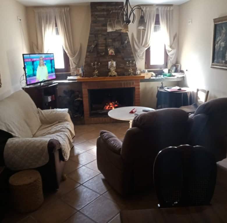 Comfortable living room with fireplace and seating in Oria, Almeria. Perfect for relaxing in a charm.