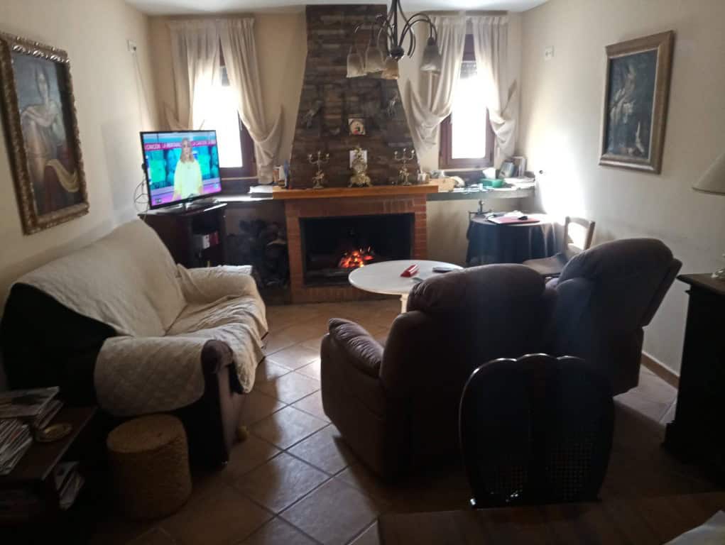 Comfortable living room with fireplace and seating in Oria, Almeria. Perfect for relaxing in a charm.
