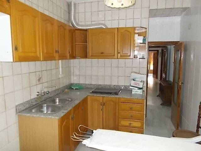 Cozy kitchen in a town house in Lucar, Almeria, featuring wooden cabinets and a tiled backsplash.