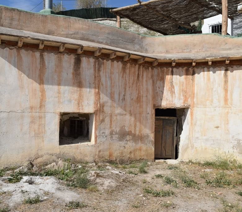 Cave house exterior in Baza, Granada, showcasing traditional adobe construction and rustic charm.