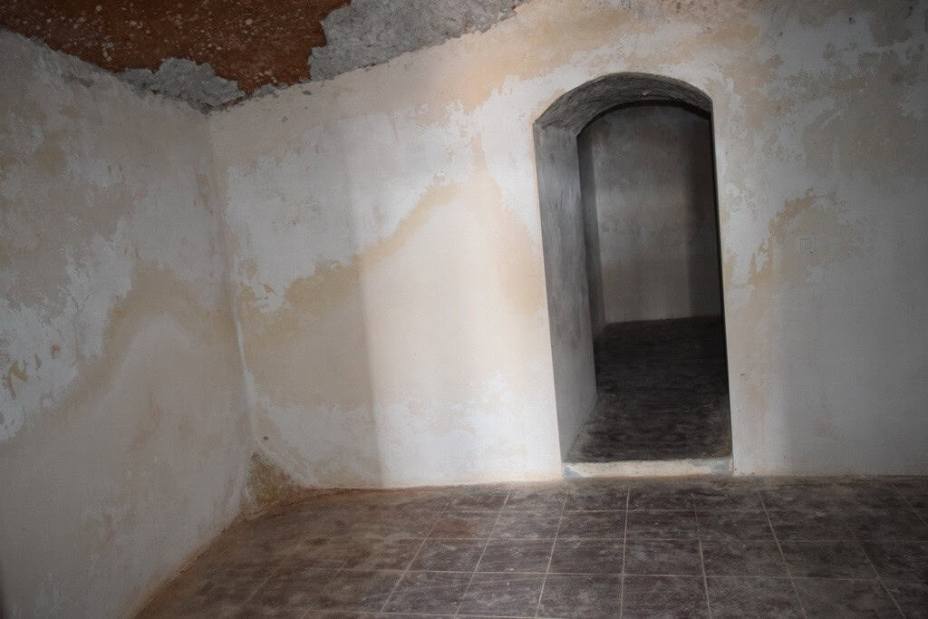Cave house interior with arched doorway and rustic walls in Baza, Granada, offering unique living sp.