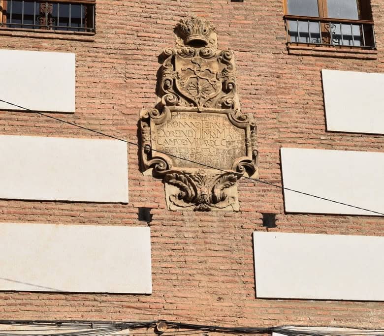 Historic town house facade in Guadix, Granada with decorative stone plaque.