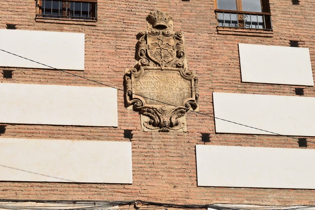 Historic town house facade in Guadix, Granada with decorative stone plaque.