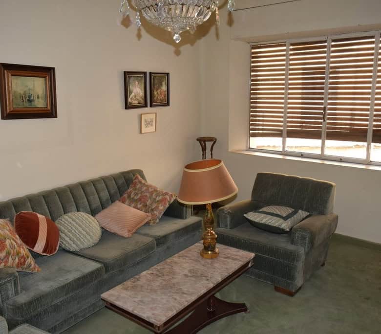 Charming living room of a town house in Guadix, Granada, featuring vintage sofas, a coffee table, an.