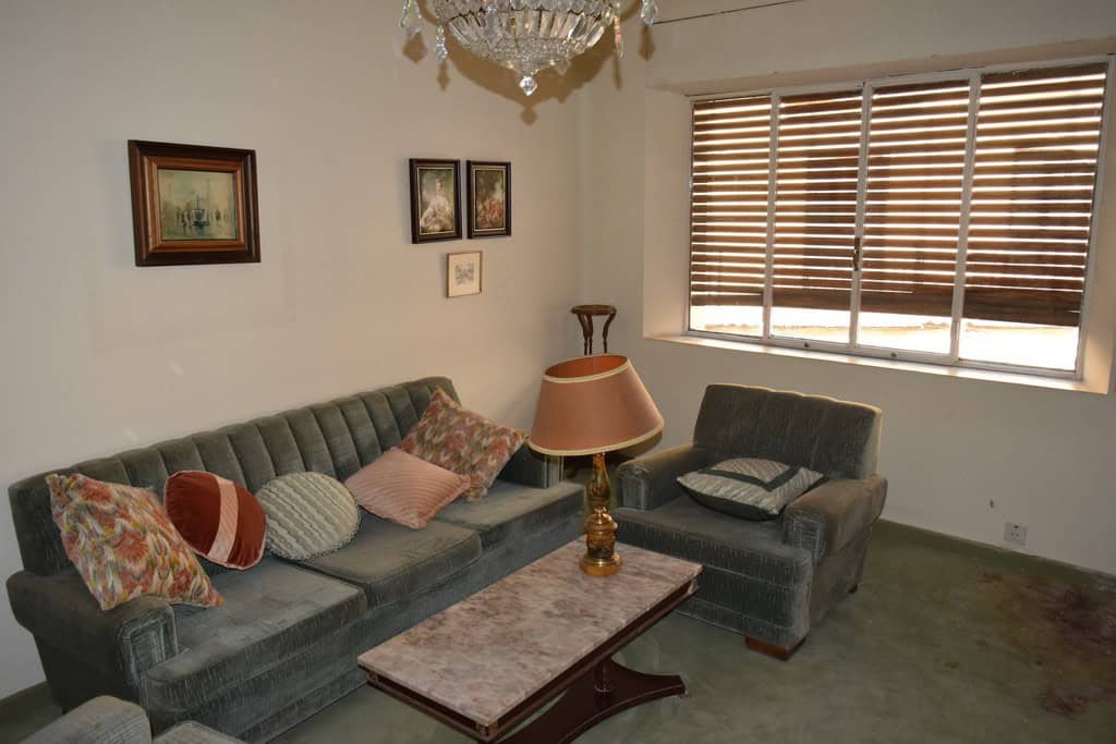 Charming living room of a town house in Guadix, Granada, featuring vintage sofas, a coffee table, an.