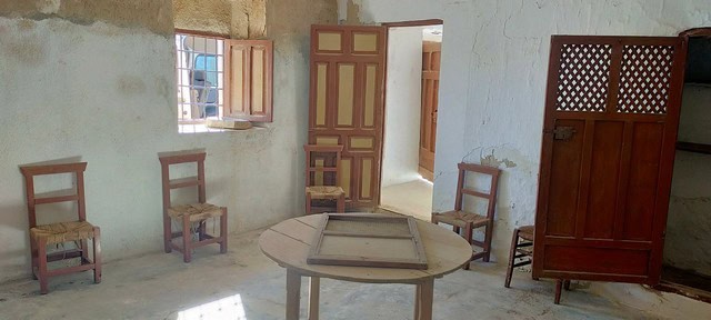 Interior view of a rustic rural property in Benamaurel, Granada, featuring simple wooden furniture a.