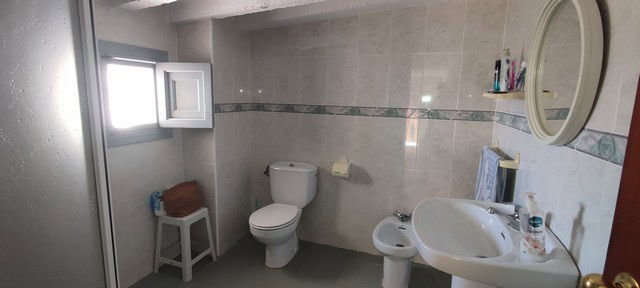 Bright bathroom in a village property in Somontin, Almeria, featuring a toilet, bidet, and sink.