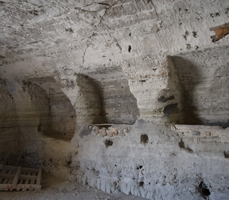 Ancient cave house interior in Baza, Granada, showcasing natural rock formations and historical arch.