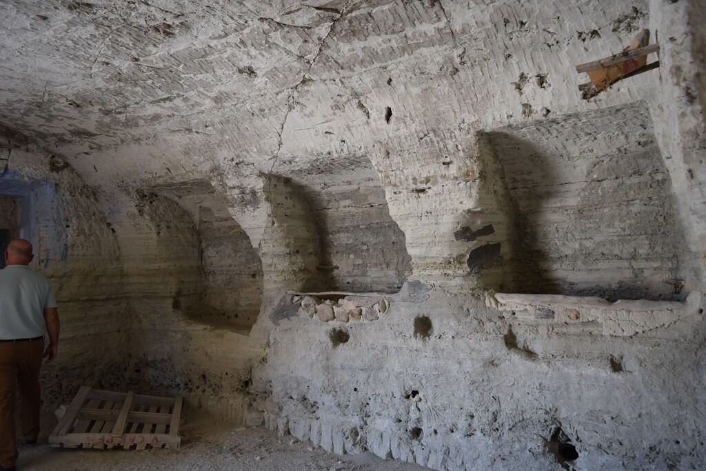 Ancient cave house interior in Baza, Granada, showcasing natural rock formations and historical arch.