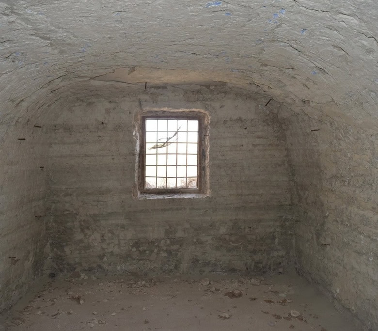 Cave house interior with a small window in Baza, Granada, showcasing traditional underground living.