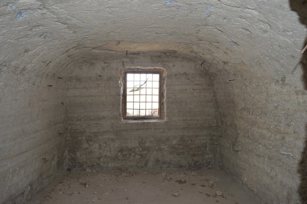 Cave house interior with a small window in Baza, Granada, showcasing traditional underground living.