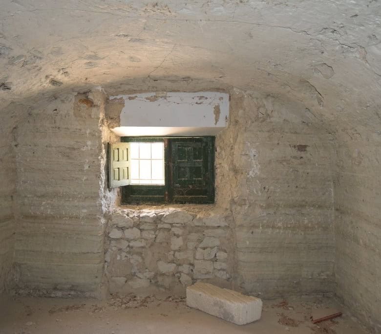Cave house interior with small window in Baza, Granada, showcasing traditional underground living sp.