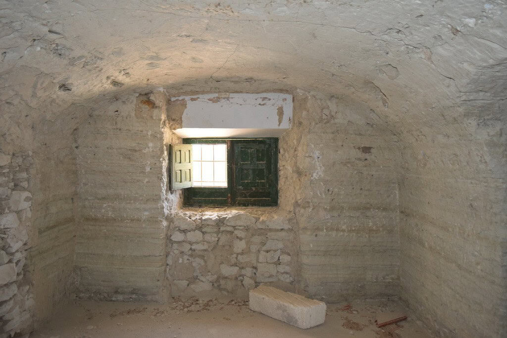 Cave house interior with small window in Baza, Granada, showcasing traditional underground living sp.