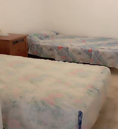 Cozy bedroom in rural property, featuring two beds and simple decor in Rosales, Jaen.