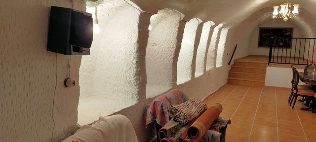 Cave house interior in Benamaurel, Granada, showcasing traditional stone walls and cozy living space.