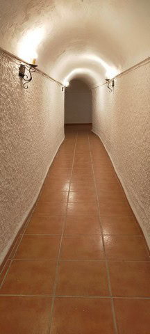 Cave house interior corridor in Benamaurel, Granada, showcasing traditional underground living space.