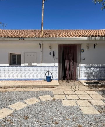 Charming village house in Gor, Granada, featuring a white exterior, tiled roof, and cozy entrance wi.