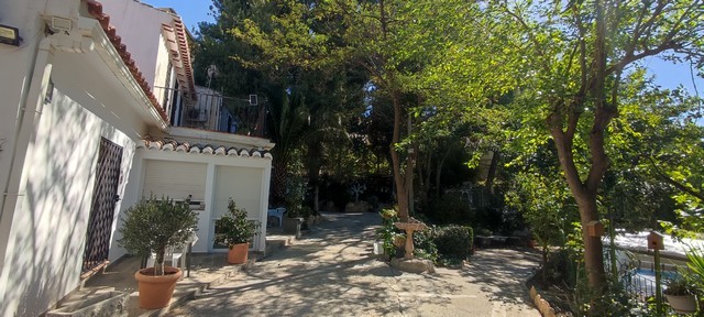 Charming cave house located in Caniles, Granada, surrounded by lush greenery and natural landscape.