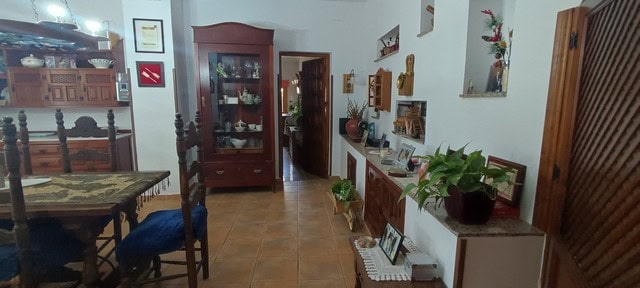 Charming cave house interior with traditional decor in Caniles, Granada, featuring wooden furniture.