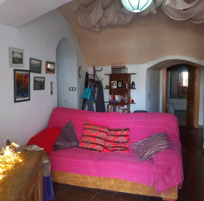 Cozy interior of a cave house in Cuevas del Campo, Granada, featuring vibrant decor and rustic charm.