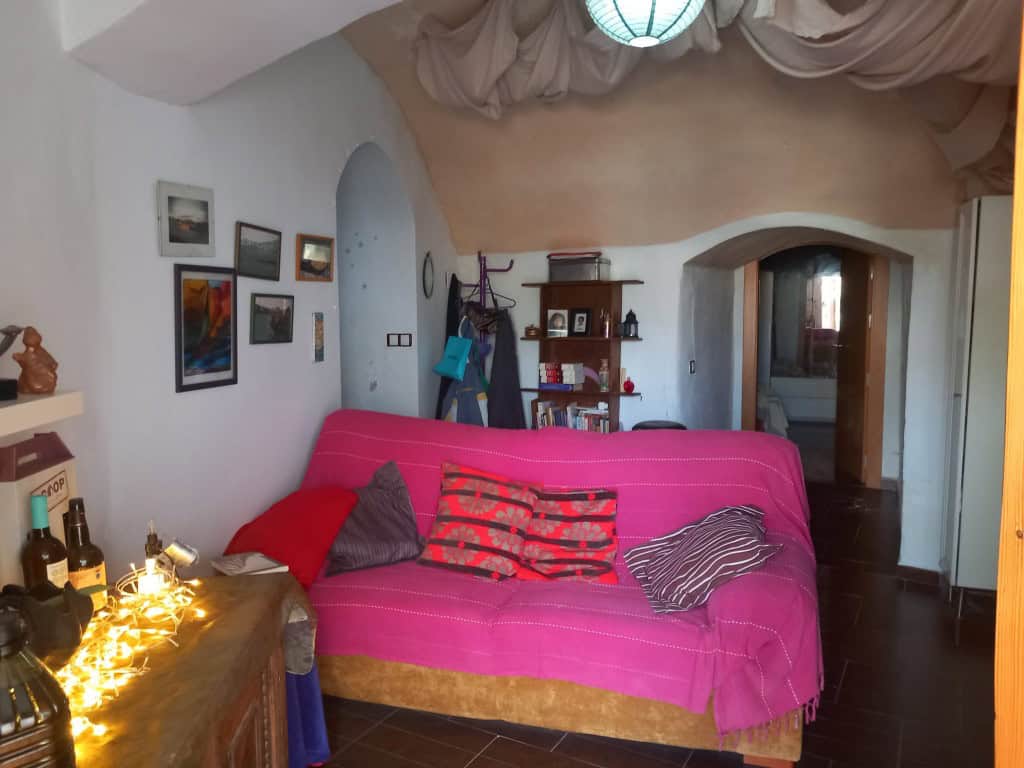 Cozy interior of a cave house in Cuevas del Campo, Granada, featuring vibrant decor and rustic charm.