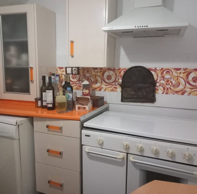 Cave house kitchen with modern appliances and colorful tile backsplash in Cuevas del Campo, Granada.