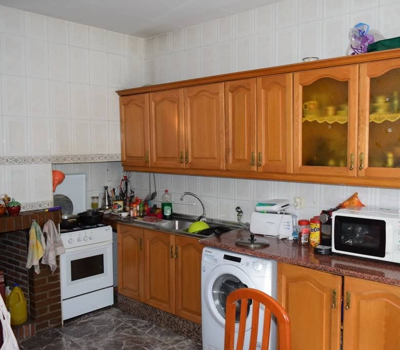 Traditional cave house kitchen with wooden cabinets and modern appliances in Granada.