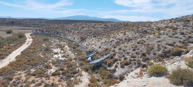 Cave house nestled in the rugged landscape of Benamaurel, Granada, surrounded by desert terrain and.