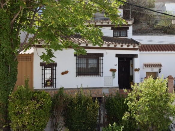 Cave house in Benamaurel, Granada, featuring traditional white walls and lush greenery. Perfect for.