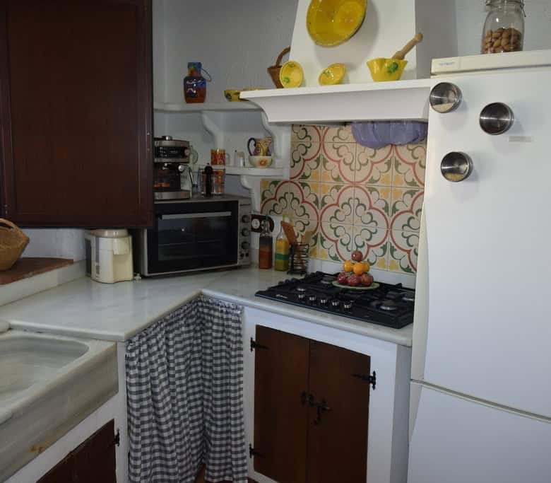 Cozy cave house kitchen in Benamaurel, Granada with rustic decor and modern appliances.
