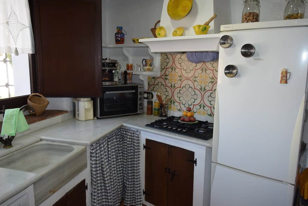 Cozy cave house kitchen in Benamaurel, Granada with rustic decor and modern appliances.