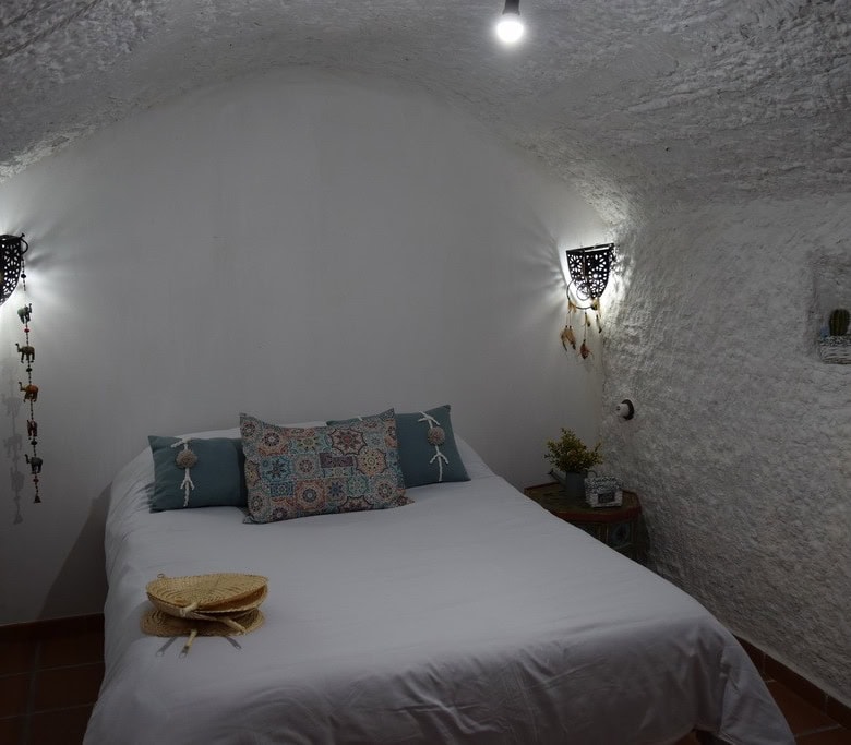 Charming cave house interior in Benamaurel, Granada, featuring white textured walls and cozy decor.