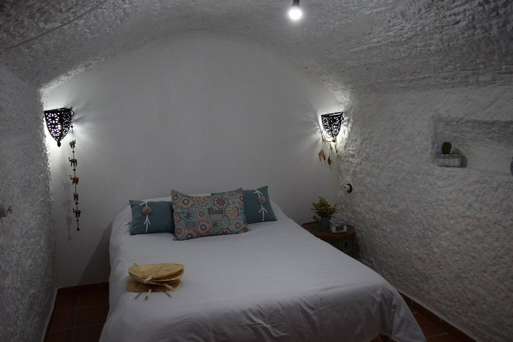 Charming cave house interior in Benamaurel, Granada, featuring white textured walls and cozy decor.
