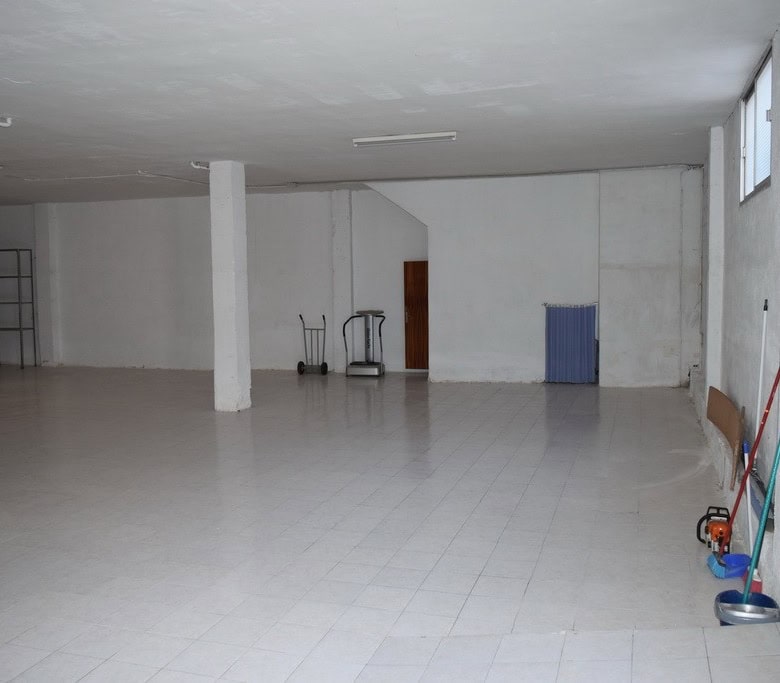 Spacious empty apartment in Baza, Granada with clean floors and large open area.