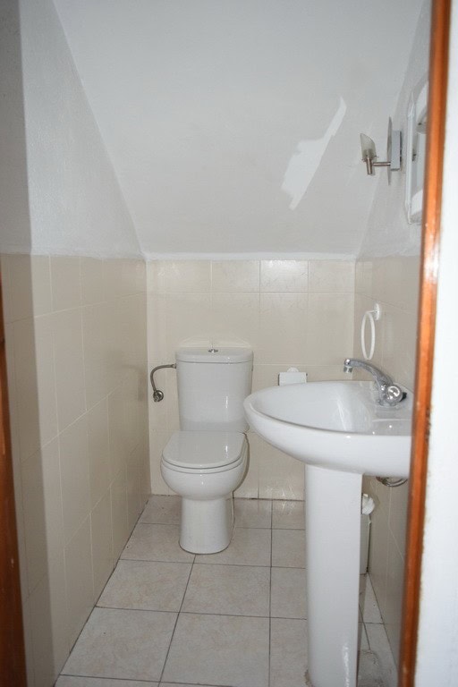 Small bathroom in Baza apartment with toilet and sink.