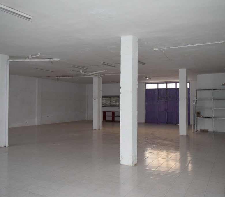 Empty commercial space in Baza, Granada with open layout and white walls.