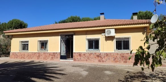 Charming villa in Armuna, Almeria with a warm yellow exterior and secure window bars. Perfect for co.