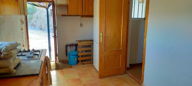 Interior view of a rustic rural property in Seron, Almeria, showing wooden doors and simple furnishi.