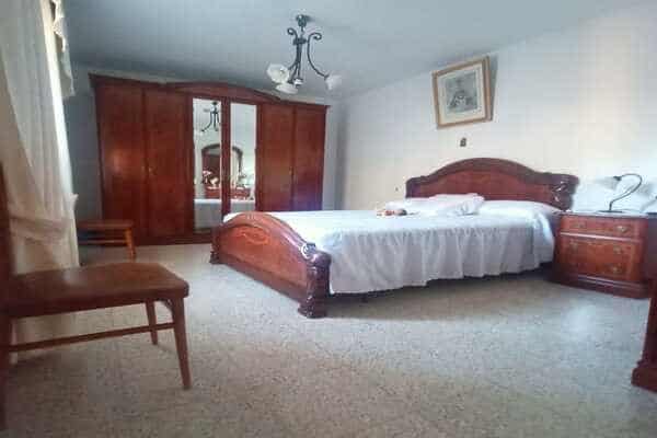 Spacious bedroom in rural property in Don Pedro, Jaen, featuring classic wooden furniture and natura.