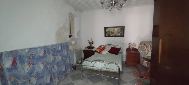 Charming town house interior in Tijola, Almeria, featuring a cozy bedroom with simple furnishings an.