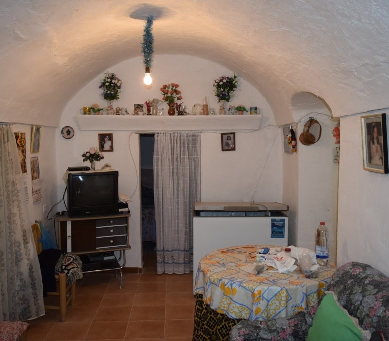 Cave house interior with white arched ceiling, vintage furniture, and cozy decor in Benamaurel, Gran.