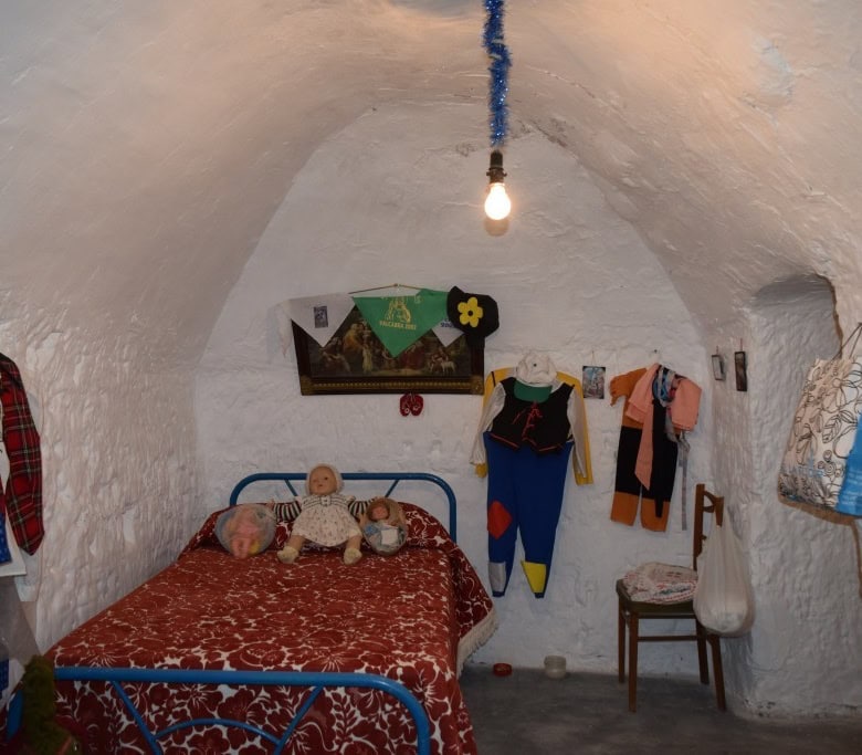 Cave house interior with traditional decor in Benamaurel, Granada, featuring a cozy bedroom with vin.