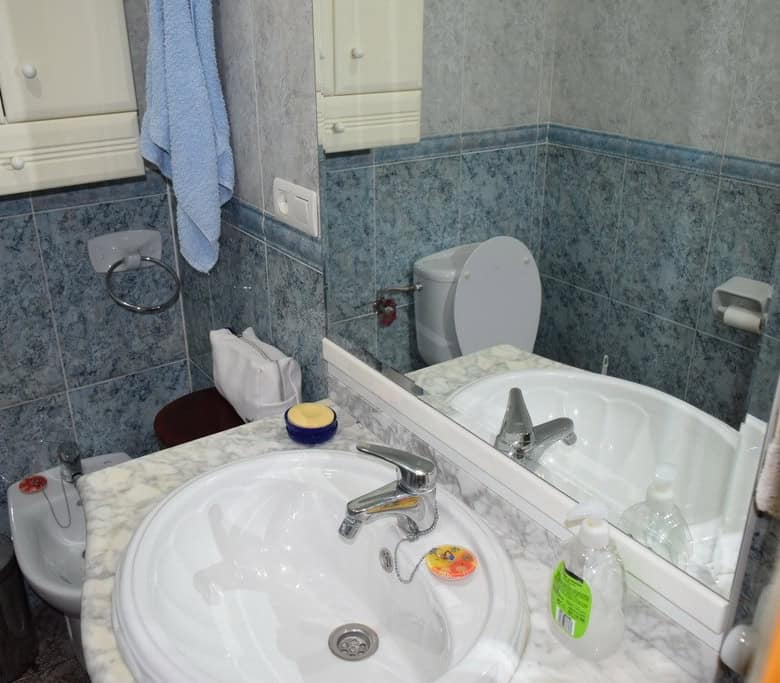 Village property bathroom with sink, toilet, and mirror in Caniles, Granada.