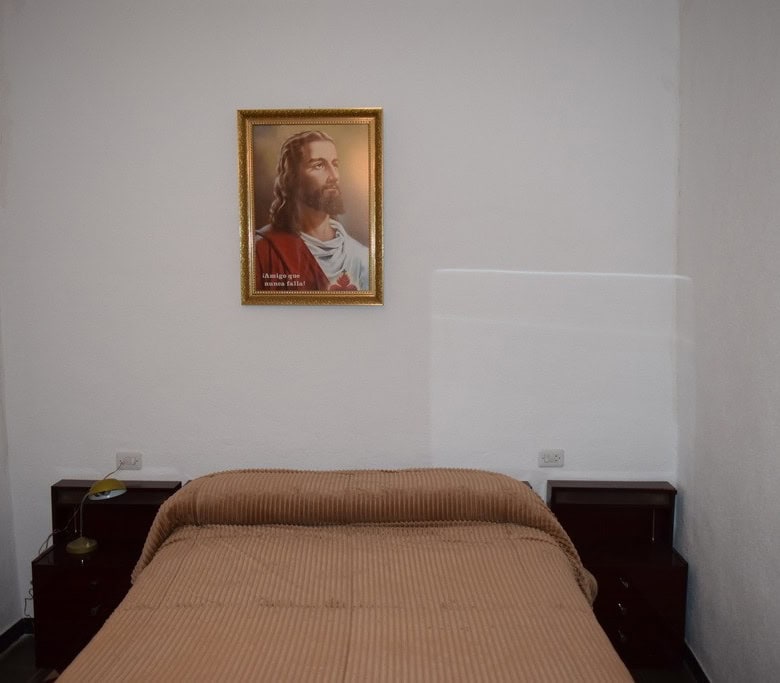 Charming village property in Caniles, Granada, featuring a cozy bedroom with religious artwork and s.