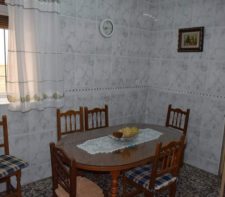 Cozy dining area in a village property in Caniles, Granada, featuring a wooden table and chairs with.