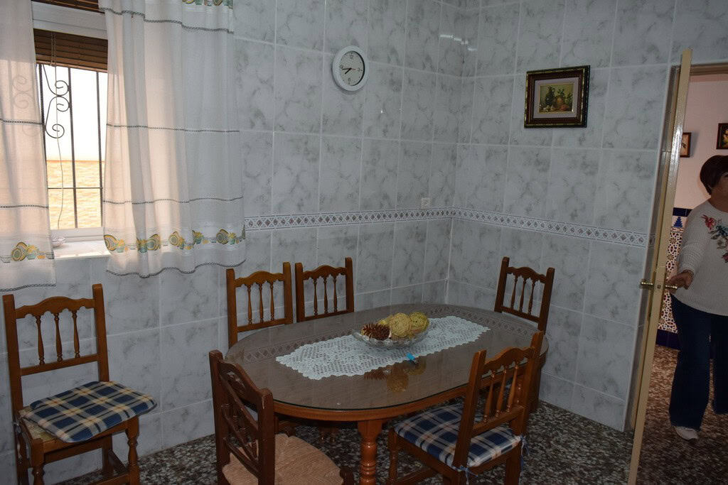 Cozy dining area in a village property in Caniles, Granada, featuring a wooden table and chairs with.