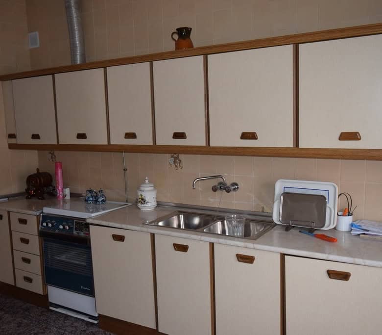 Kitchen with white cabinets and stainless steel sink in Caniles village property, Granada.