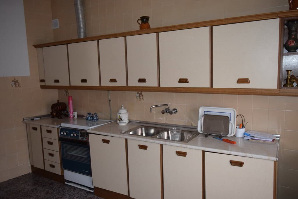 Kitchen with white cabinets and stainless steel sink in Caniles village property, Granada.