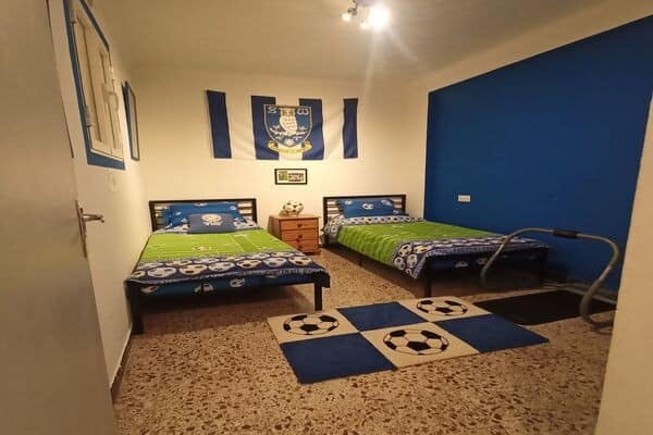 Cozy bedroom with two single beds and sports-themed decor in Hinojares, Jaen village property.
